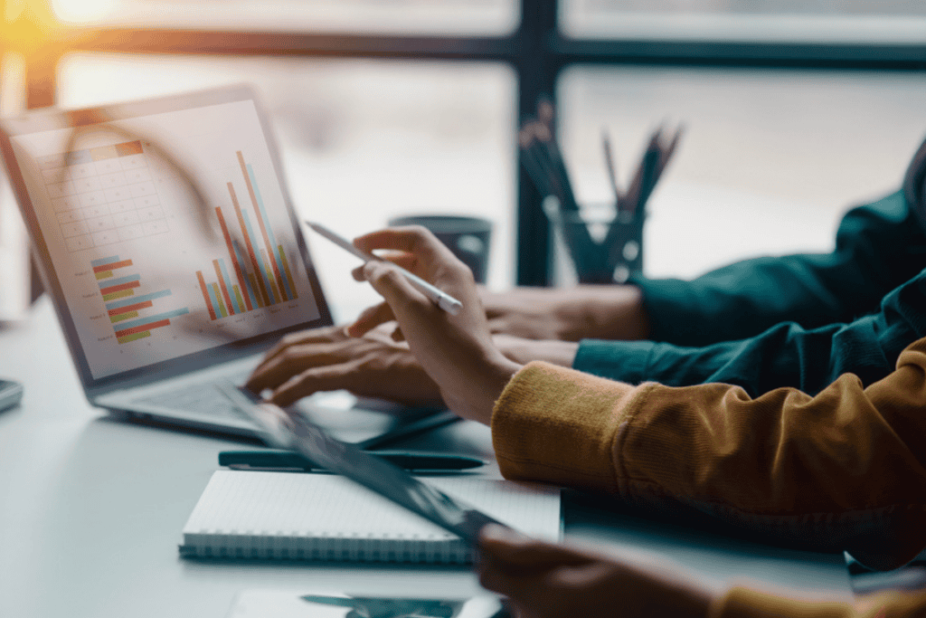 Two people reviewing data charts on a laptop